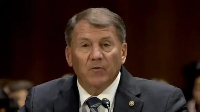 Rounds speaks and looks into the camera