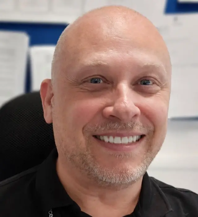 Mark Tait smiling as he looks towards the camera