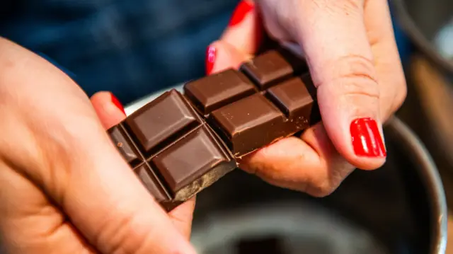 Woman breaking chocolate