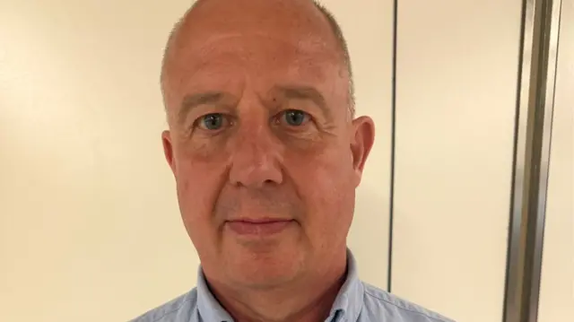 A man wearing a light blue shirt.