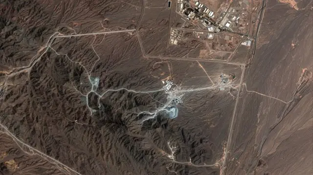 A satellite image shows the Natanz nuclear facility with brown dirt and some buildings