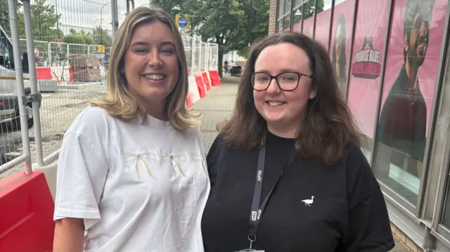 Jo and Abbie stand next to each other in the middle of a street in Sheffield