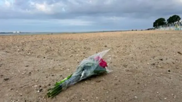 Floral tribute left on a beach