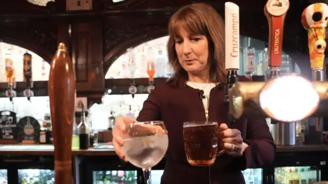 Rachel Reeves holds a gin and tonic and a pint behind the bar of a pub