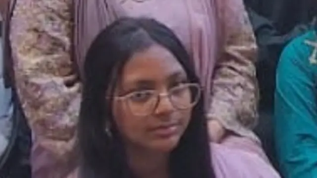 A woman wearing a pink dress while wearing glasses