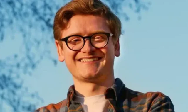 Richard Kilpatrick has red hair and wears black glasses