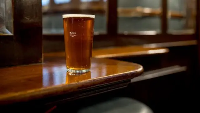 A full pint on top of a wooden table