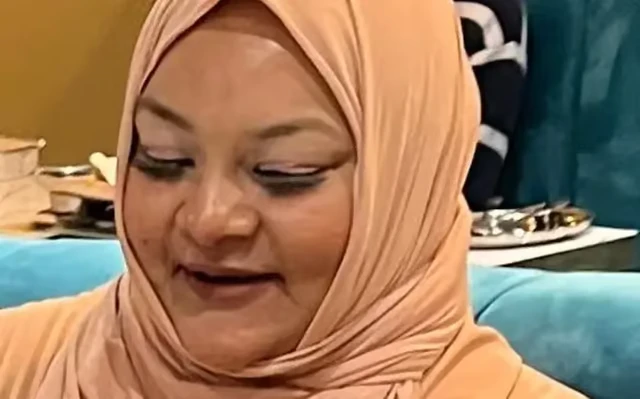 A woman wearing a cream hijab