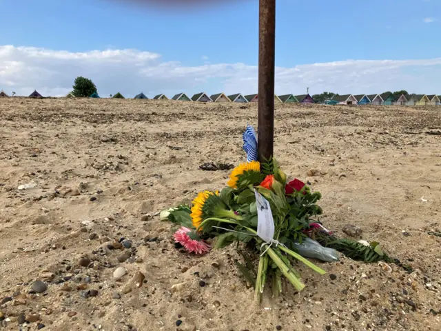 Flowers have been left on the sand