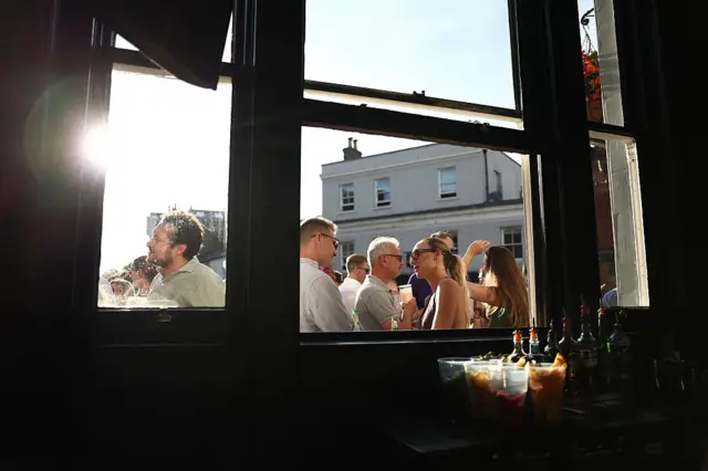 People stood outside of a pub window