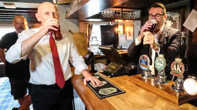 Andy Burnham pulls a pint with the Chancellor on the other side of the bar