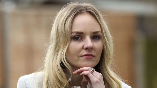 Close up of Lissie Harper, a woman in her early 30s with long blonde hair and her chin resting on her left hand