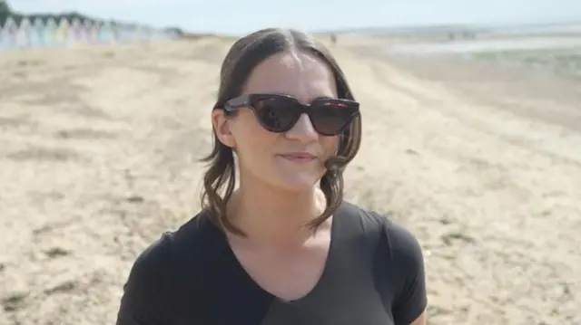 A woman wearing sunglasses on the beach