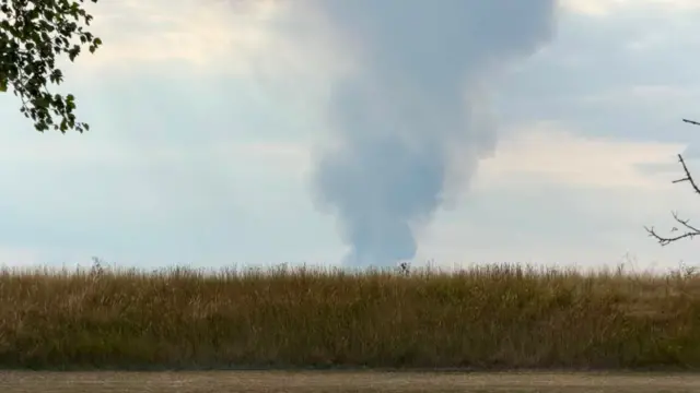 Smoke rising above a field.