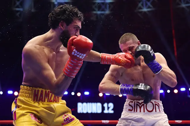Hamzah Sheeraz punching Simon Zachenhuber