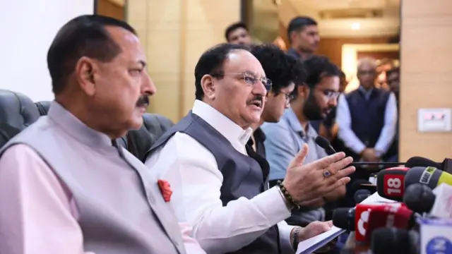 Nadda seen in a white shirt and dark grey vest with Jitendra Singh and CJP spokespersons Saurav Das and Ashutosh Ranka on either side