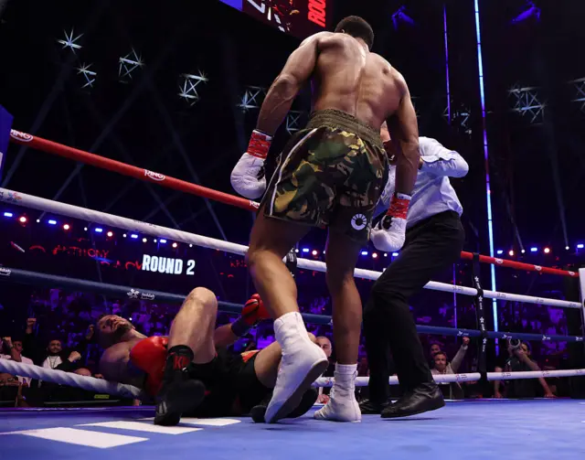 Anthony Joshua standing over Kristian Prenga