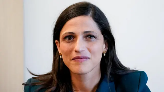 Éléonore Caroit looks towards the camera as her portrait is taken. She is wearing a dark blazer