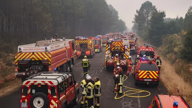 Dozens of firefighters set up their equipment on a support line between the villages of Lacanau and Saint-Helene in the Bordeaux region