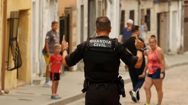 A security officer takes part in an evacuation operation for the village of Cadalso de los Vidrios, Madrid