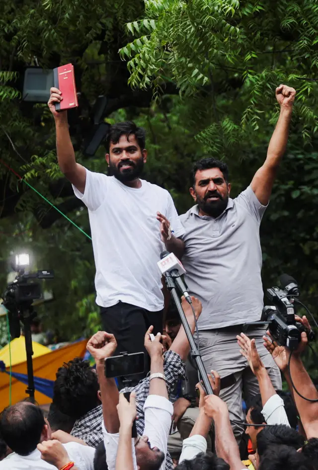 Abhijeet Dipke, head of the Cockroach Janta Party (CJP), celebrates with supporters after the resignation of Education Minister Dharmendra Pradhan
