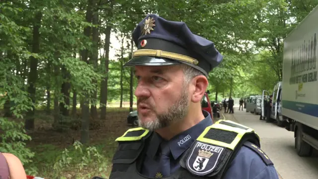 Florian Nath is pictured speaking in a police uniform against a background of trees