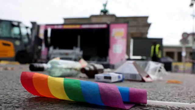 rainbow flag lies on the ground as parade infrastructure is dismantled near the Brandenburg Gate, after a deadly incident in which a vehicle crashed into a crowd near Berlin's annual Christopher Street Day Pride parade on Saturday evening