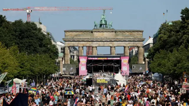 Crowds walk near a stage in front of Brandenburg Gate in Berlin during pride celebrations on Saturday