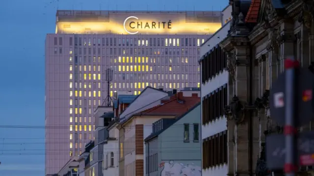 The exterior of a hospital is shown at dusk.
