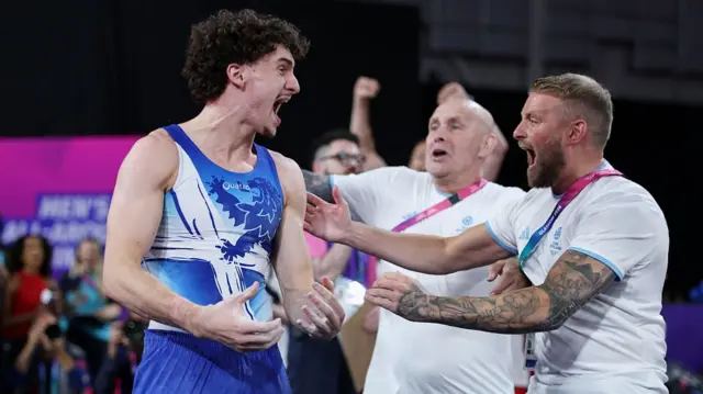 Gold medalist Reuben Ward of Team Scotland celebrates victory with teammates after the Men's All-Around
