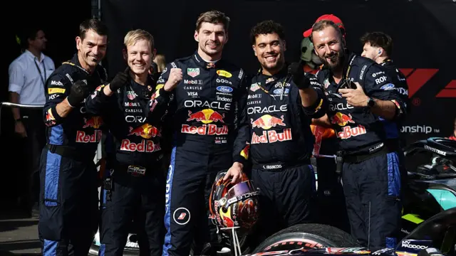 Max Verstappen smiling with Red Bull engineers after the race