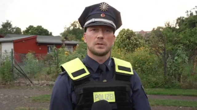 A police officer looking at the camera speaking