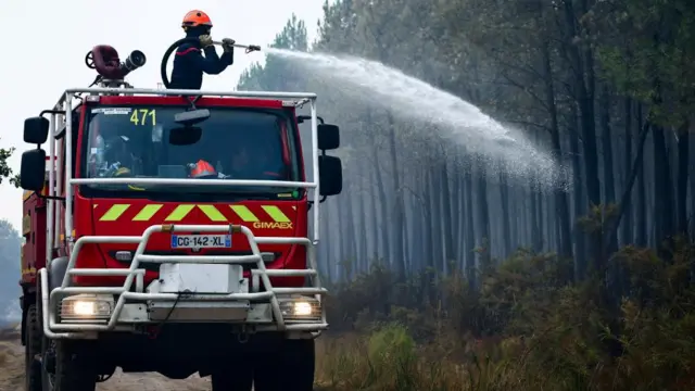 A fire engine carries out edge protection and mop-up operations on a wildfire in Saint-Jean d'Illac, in the Gironde region
