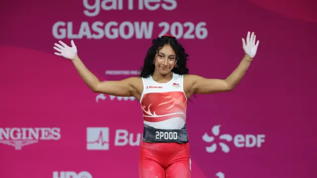 Noorin Gulam waves at the crowd after exiting the 53kg weightlifting contest in Glasgow