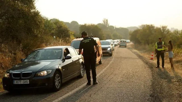 Cars line up with traffic officers speaking through driver windows