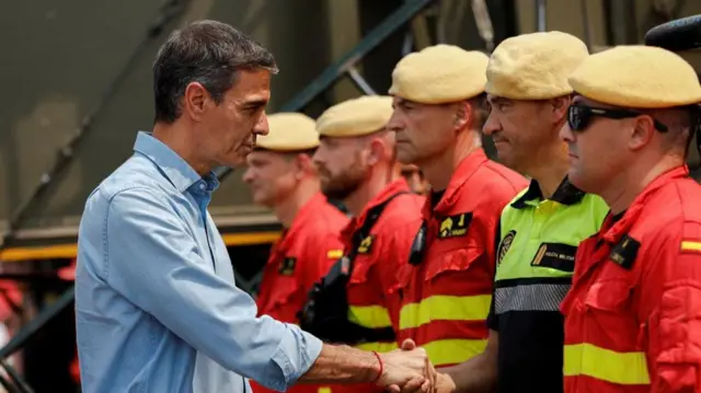 Spanish Prime Minister Pedro Sanchez meets members of emergency services as he visits an area affected by a wildfire in La Vall d'Uixo, Castellon province, Spain, July 27, 2026.