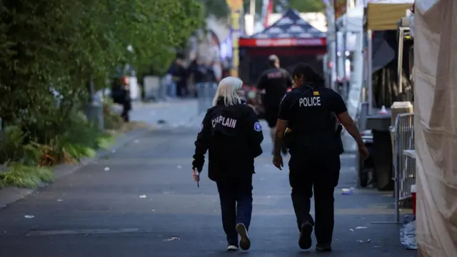 A Seattle fire department chaplain and a police officer walk in an area after Seattle Police responded to what they described as a shooting with "multiple" victims at Seattle Center, which was hosting a Bite of Seattle food festival, in Seattle, Washington, U.S