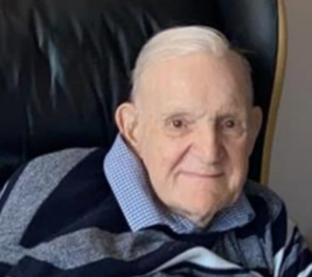 An elderly man sat in a chair