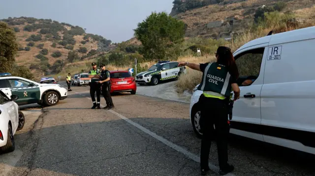 A police officer helps regulate traffic on a rural road