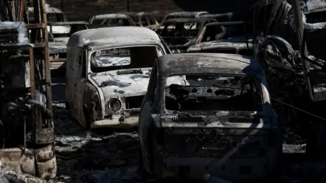 Charred cars seen on Monday in the village of Chapineria, around 50km west of Madrid