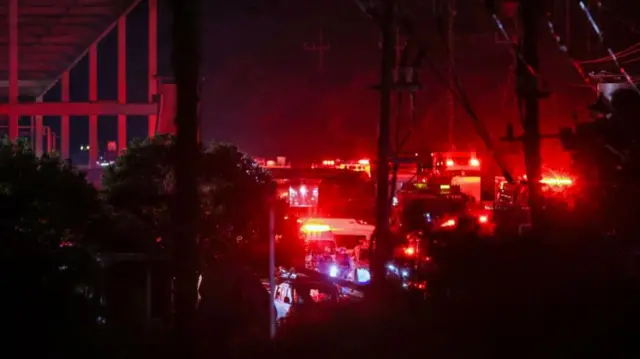 Multiple cars with red lights parked outside a building at night time