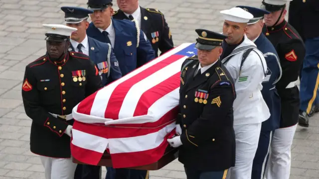Graham's casket arrives at US Capitol. It is draped in a US flag and carried by military service members