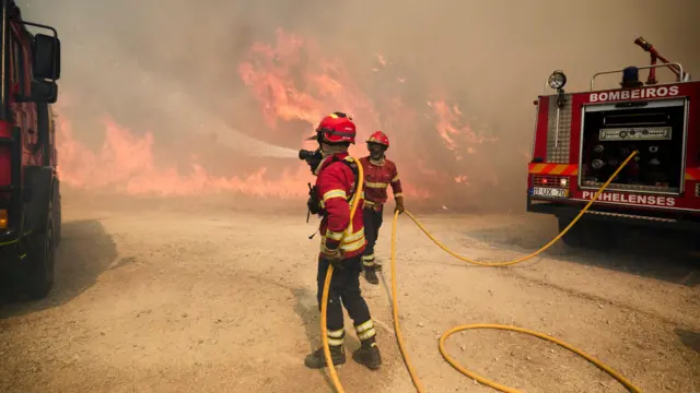Firefighters battle the flames of a wildfire near the village of Pinzio, Portugal, 28 July 2026.
