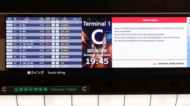 Departure board at Tokyo's Haneda Airport showing departure delays
