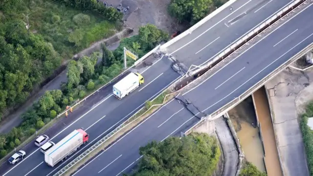 Lorries and cars on damaged road bridge