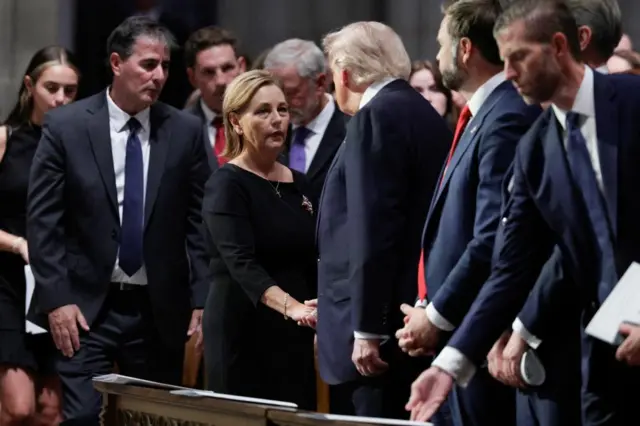 US Senator Darline Graham Nordone shakes hands with President Donald Trump during the funeral service for her late brother Senator Lindsey Graham