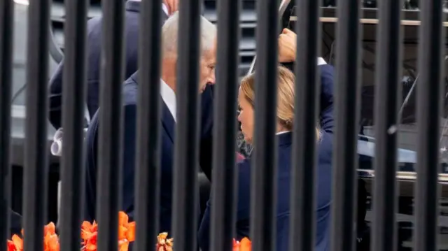 Netanyahu getting into a car, while a security agent holds it for him