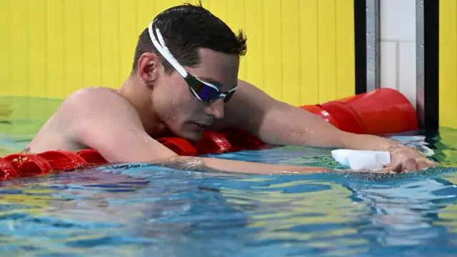 Duncan Scott, wearing goggles, looks dejected in the pool while leaning on the red lane separator after failing to reach the final of the 2026 Commonwealth Games 200m freestyle