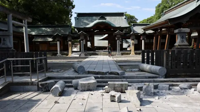Stone pillars and bricks are spread across the floor at the Yatshushiro Shrine