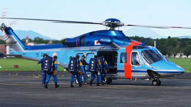 Rescuers board a helicopter to search for those still missing after an earthquake struck Kumamoto